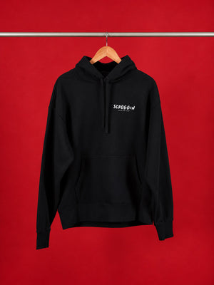 A black pullover hoodie with a white 'SCROGGIN' text logo on the left chest, hanging on a wooden hanger from a metal rod against a solid red background.
